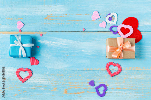 Present gift box with hearts for Valentine day on the blue wooden background with copy space