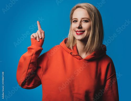 girl in orange hoodie on blue background