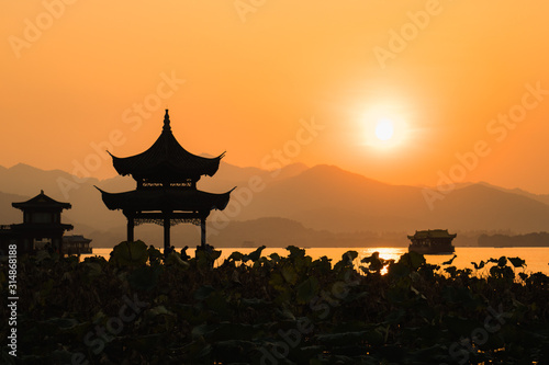 Sunset panoramic view of the West Lake in Hangzhou, China. Beautiful silhouette in sunset colors.