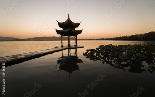 Sunrise panoramic view of the West Lake in Hangzhou, China. Beautiful silhouette in sunset colors.
