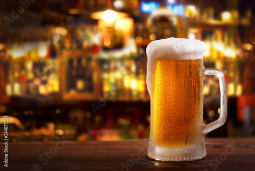 Canvas Print cold mug of beer in a bar on wooden table