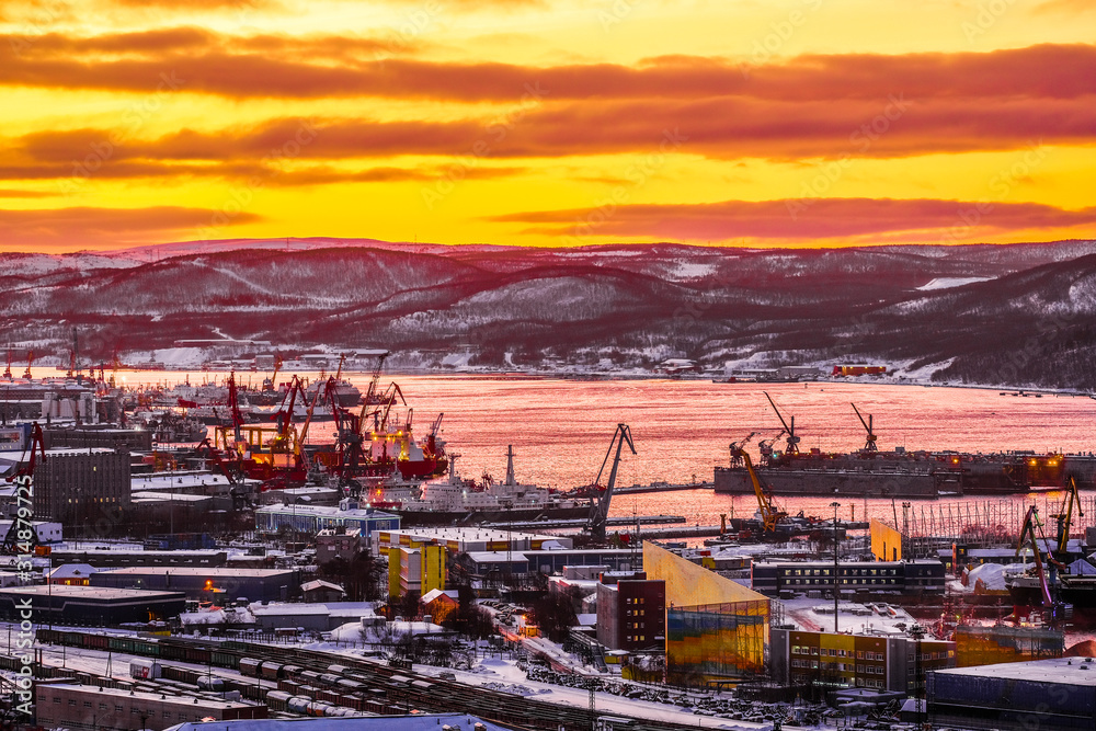 Murmansk, Russia - January, 5, 2020: Non-freezing seaport in the city of Murmansk in winter. The picture was taken at 2 p.m. in natural light at the height of a polar night