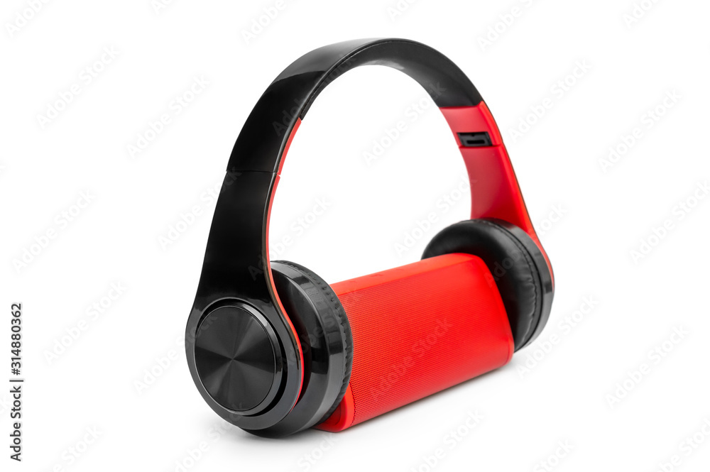 Red small audio speaker with headphones on white. Red small audio speaker with headphones on white.