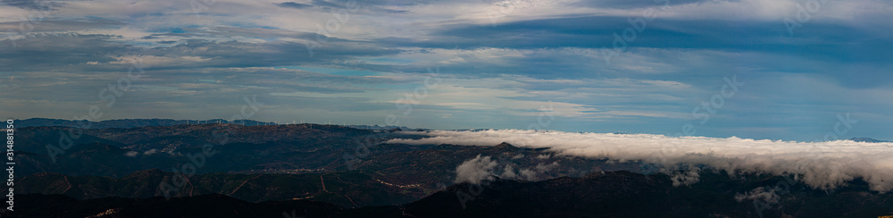 Mountainous landscape with clouds and fog, panoramic image