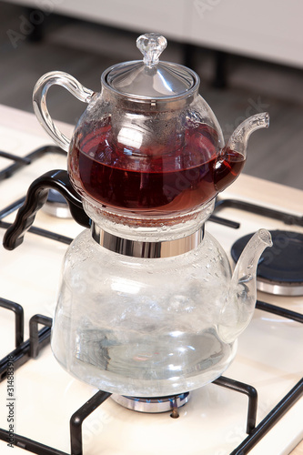 Glass teapot on wooden counter of open plan kitchen photo