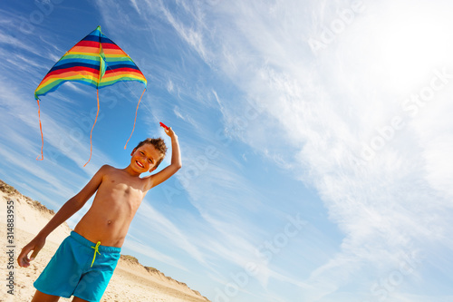 Colorful kite hold by boy on a beach over blue sky