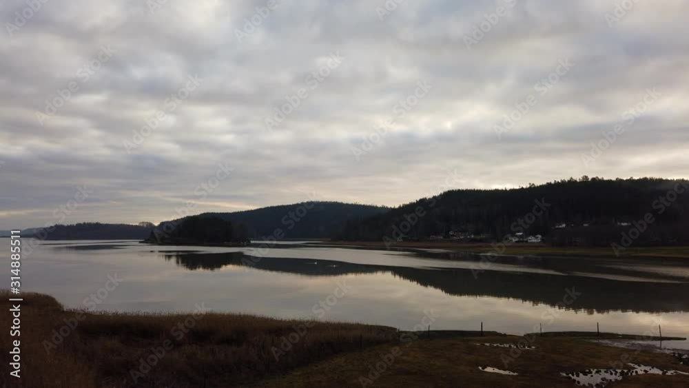 Heavy overcast clouds move across glass calm lake in evening timelapse Heavy overcast clouds move across glass calm lake in evening timelapse