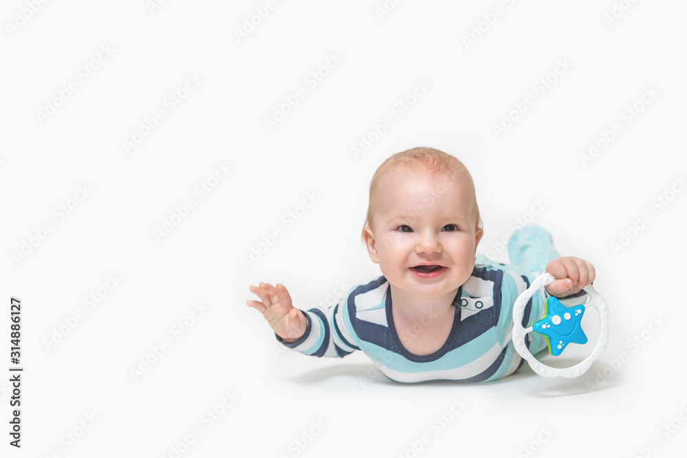 Laughing baby boy is lying on white background holding a toy. All potential trademarks are removed. Laughing baby boy is lying on white background holding a toy. All potential trademarks are removed.