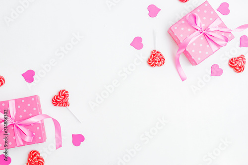 Flat lay valentines day frame with gift box and red sweets on a white background