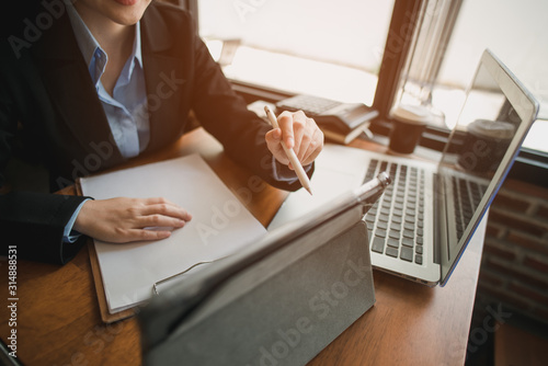 business woman working at office with laptop, tablet and documents on his desk.
