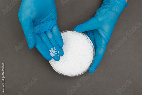 Plastic granules . Polypropylene, polyethylene pellets in hands with gloves. Quality control of plastic in the laboratory in production