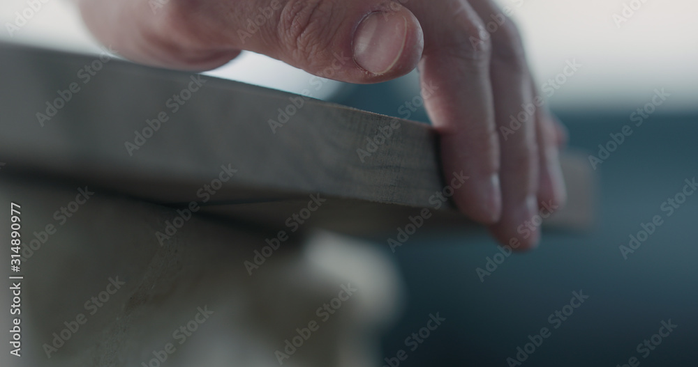 woodworker touching untreated black walnut board woodworker touching untreated black walnut board