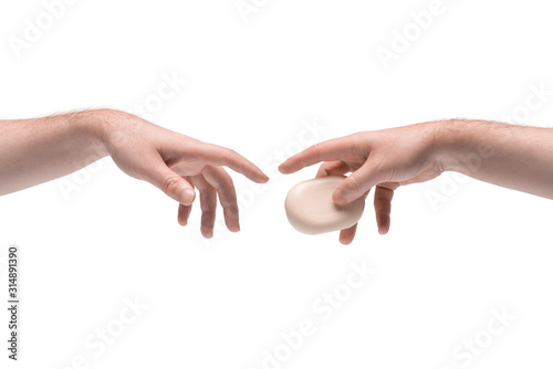 Two male hands passing one another a soap on white background