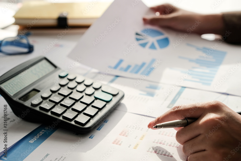 business woman working on desk office with using a calculator to calculate the numbers, finance accounting concept business woman working on desk office with using a calculator to calculate the numbers, finance accounting concept
