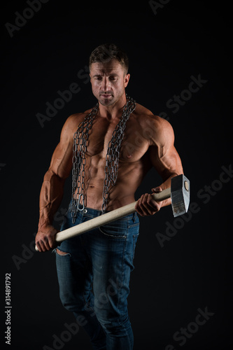 Brutality concept. Bodybuilder concept. Healthy and strong. Attractive guy muscular body. Bodybuilder brutal guy. Man fitness training with heavy hammer. Mining industry. Coal miner workshop