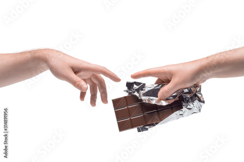 Two male hands passing one another chocolate bar in foil on white background (ID: 314891956)