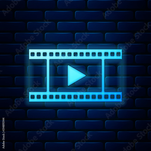 Glowing neon Play Video icon isolated on brick wall background. Film strip with play sign. Vector Illustration