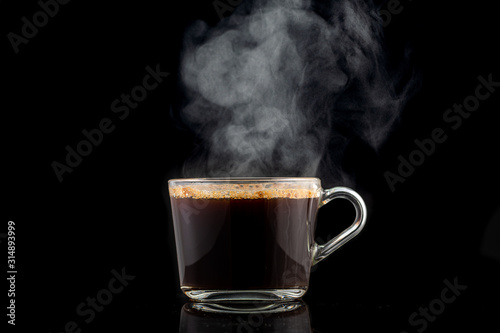 splash and splatter from a piece of sugar in a mug with coffee on a black background photo