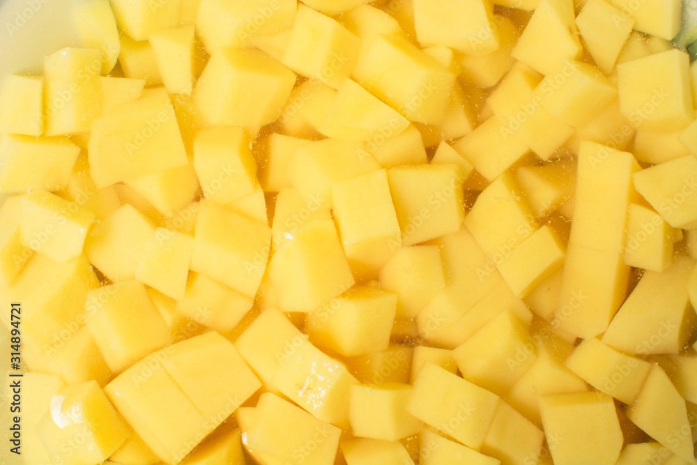 Raw sliced potatoes lay in plate of water to get rid of nitrates and nitrites. Raw sliced potatoes lay in plate of water to get rid of nitrates and nitrites.