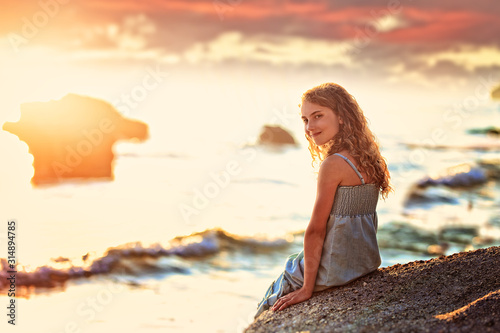 joyful and cheerful girl is sitting on the beach