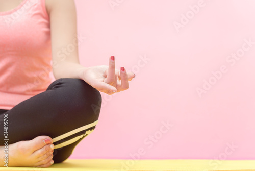 Young woman practicing yoga, sitting in Half Lotus exercise,