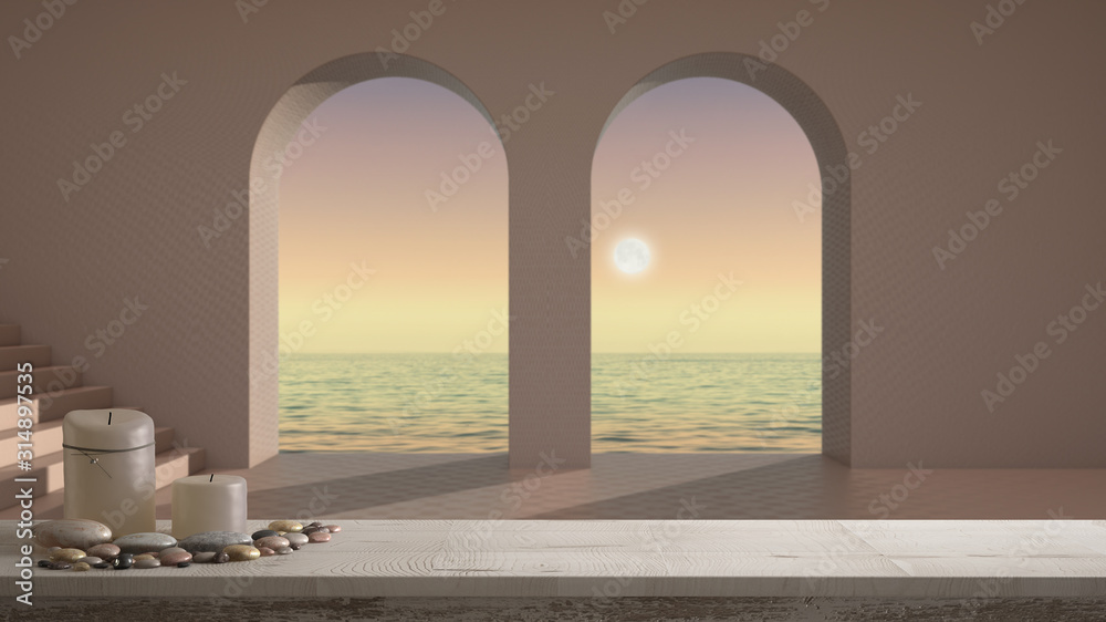 Wooden vintage table top or shelf with candles and pebbles, zen mood, over empty space with arched window and staircase, terrace with sea sunset panorama, architecture interior design