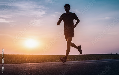 The man with runner on the street be running for exercise. - Image