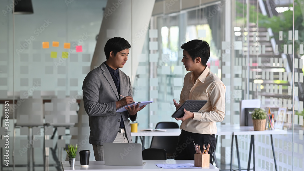 Photo of young business consulting man while talking/giving an advice to young professional man. Photo of young business consulting man while talking/giving an advice to young professional man.