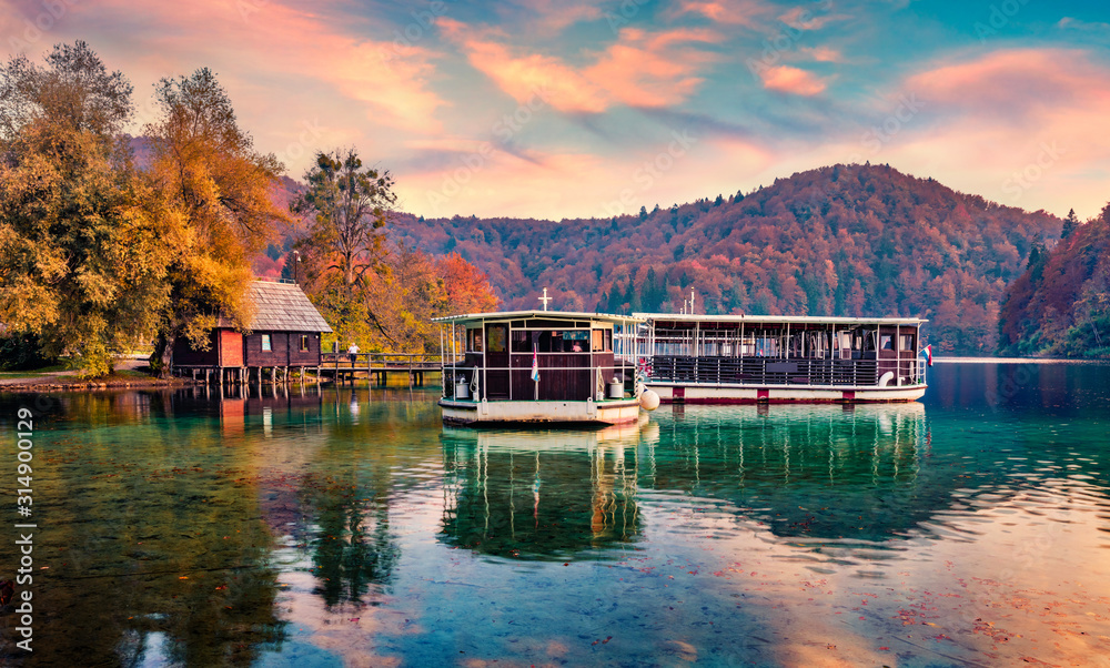Excursion ships on the lake. Amazing autumn sunset on Plitvice lake. Splendid evening landscape of Croatia, Europe. Traveling concept background. Excursion ships on the lake. Amazing autumn sunset on Plitvice lake. Splendid evening landscape of Croatia, Europe. Traveling concept background.