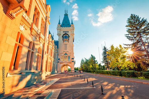 Colorful evening view of Cultural Palace Iasi. Sunny summer cityscape of Iasi town, capital of Moldavia region, Romania, Europe. Architecture traveling background.