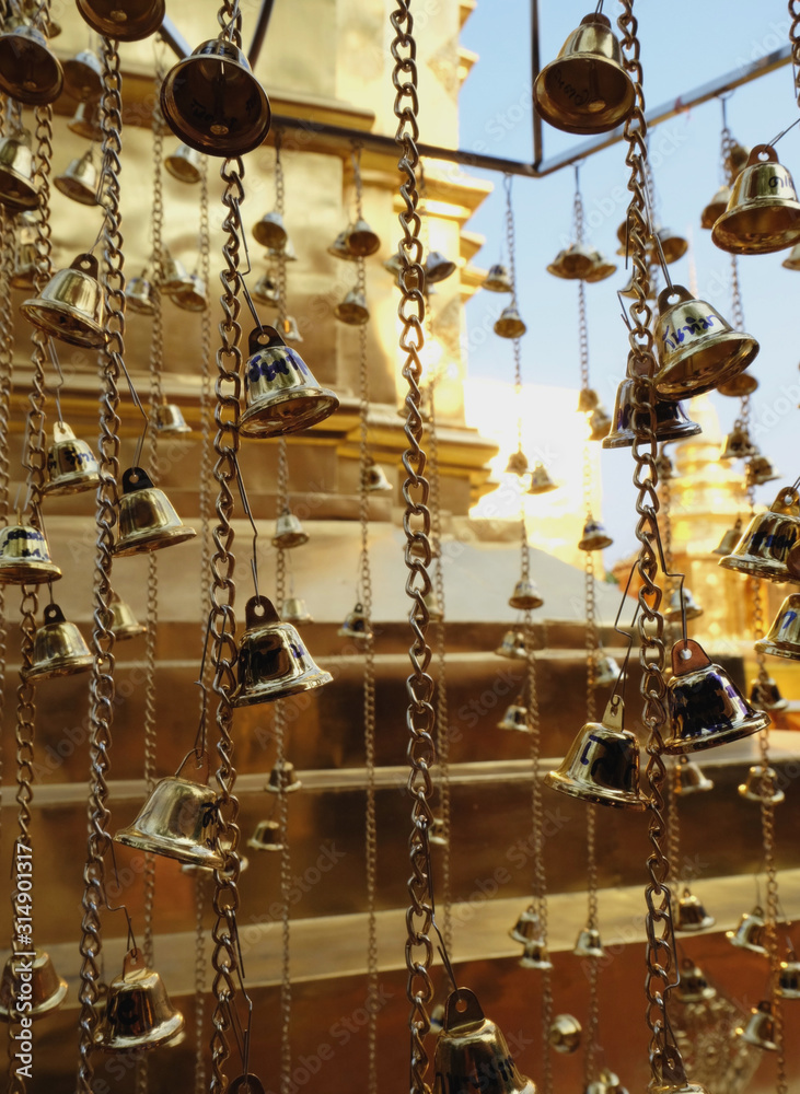 Many golden buddhist bells with wishes in sunlight