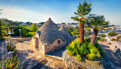 Amazing morning view of strret with trullo - traditional Apulian dry stone hut with a conical roof. Impressive spring cityscape of Alberobello town, province of Bari, Apulia region, Italy, Europe.