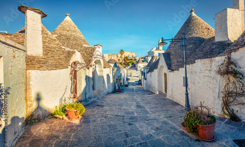 Colorful morning view of strret with trullo  -  traditional Apulian dry stone hut with a conical roof. Nice spring cityscape of Alberobello town, province of Bari, Apulia region, Italy, Europe. photo