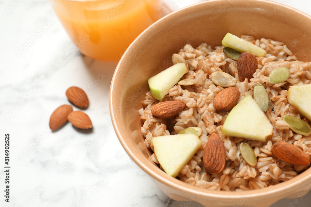 Tasty oatmeal with apples and almonds on light table, closeup. Healthy breakfast Tasty oatmeal with apples and almonds on light table, closeup. Healthy breakfast