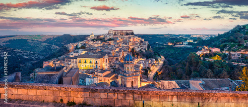 Panoramic spring cityscape of Ragusa town with Palazzo Cosentini and Duomo di San Giorgio church on background. Colorful sunset in Sicily, Italy, Europe. Traveling concept background.