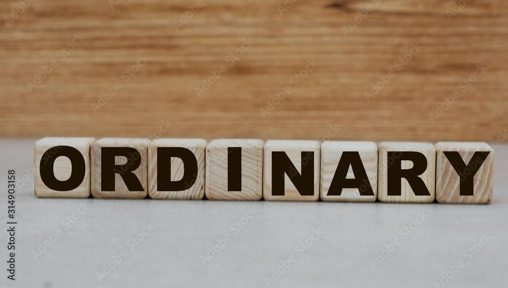 the concept of the word ordinary on cubes on a wooden background the concept of the word ordinary on cubes on a wooden background