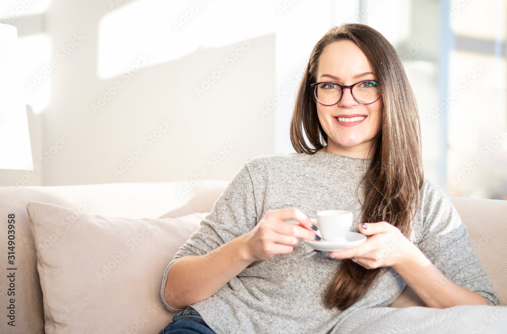 Brunette haired young woman drinking coffee at home Brunette haired young woman drinking coffee at home