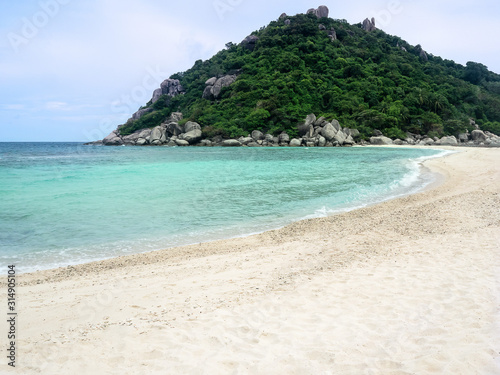 Idyllic tropical paradise beach white sand and crystal clear sea blue sky with green hill Island.