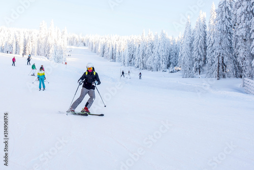 Young man skiing in mountain ski resort with beautiful winter landscape in the background