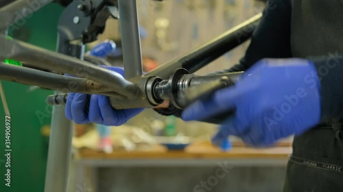 Young male repair bmx bicycle in workshop 4K UHD	