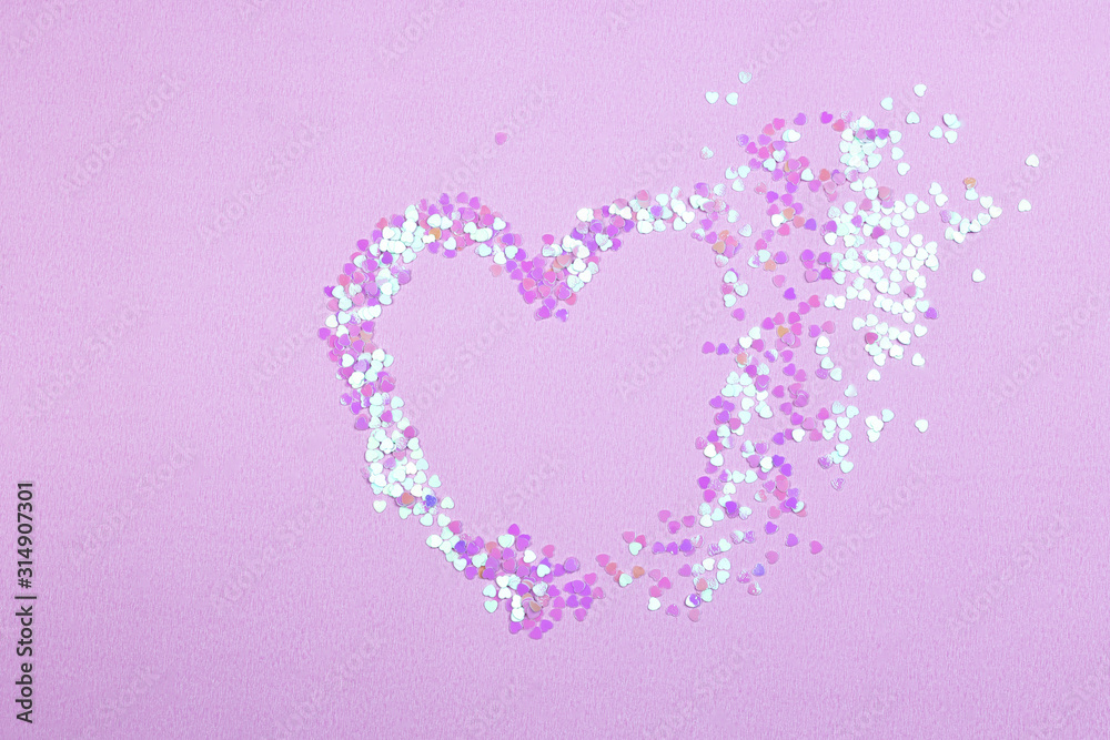 Broken heart made from confetti on pink background. Broken heart breakup concept separation and divorce image.