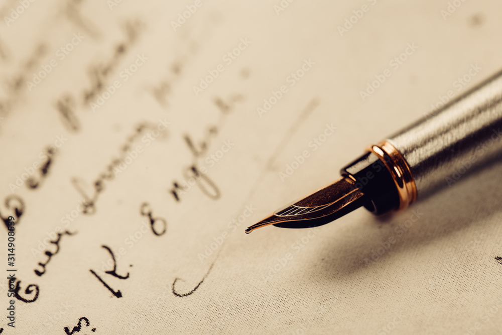 Fototapeta premium Fountain pen on an ancient handwritten letter. Old story. Retro style.
