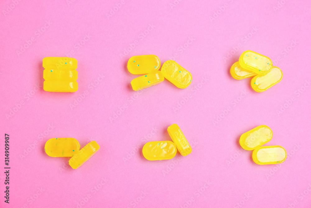 Tasty lemon drops on pink background, flat lay Tasty lemon drops on pink background, flat lay