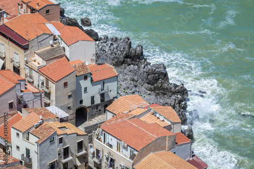 Residential buildings on the shore of Tyrrhenian Sea in historic part of Cefalu city on Sicily Island in Italy photo