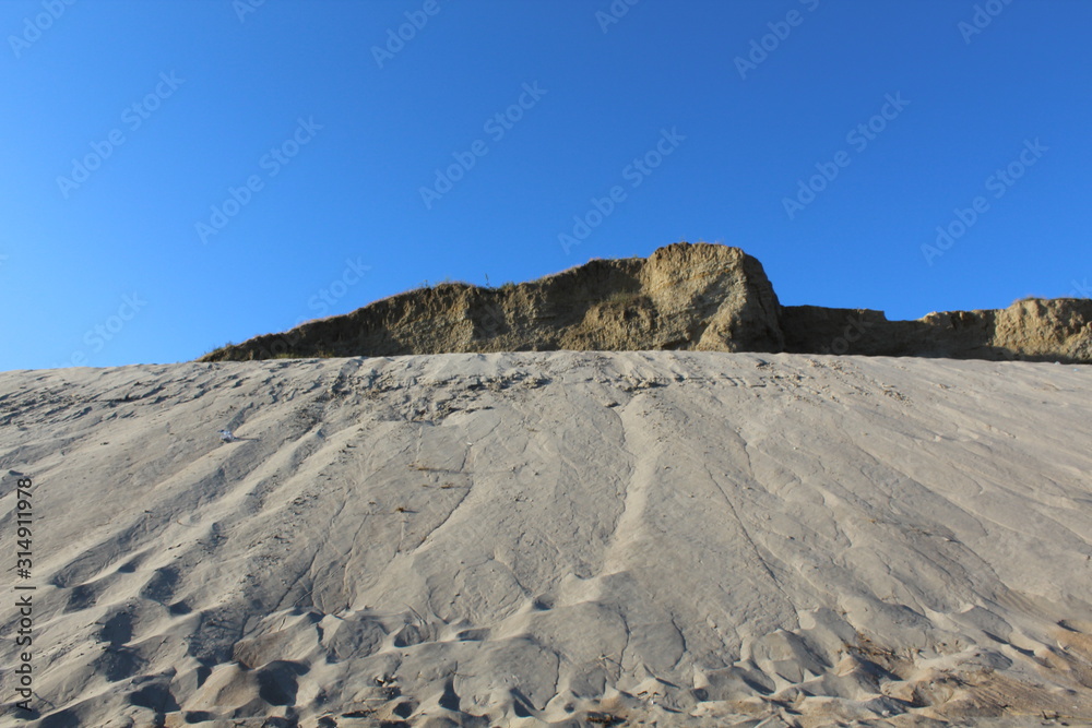 Gray sand on a background of blue sky