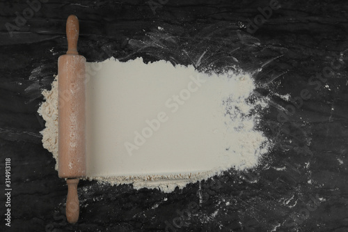 Fototapeta Naklejka Na Ścianę i Meble -  Flour and rolling pin on grey marble table, flat lay with space for text