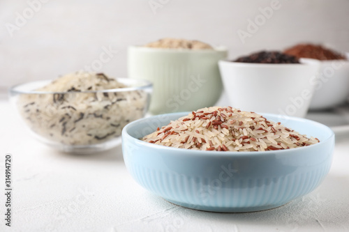 Mix of brown and polished rice on white table, closeup