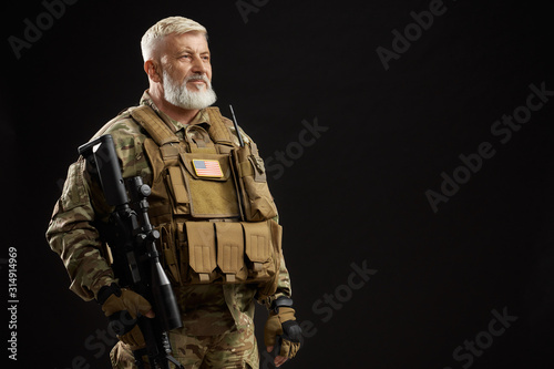Old military officer holding sniper rifle.