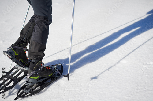 Athlete man walking through snow with snowshoes, detail of snowshoes