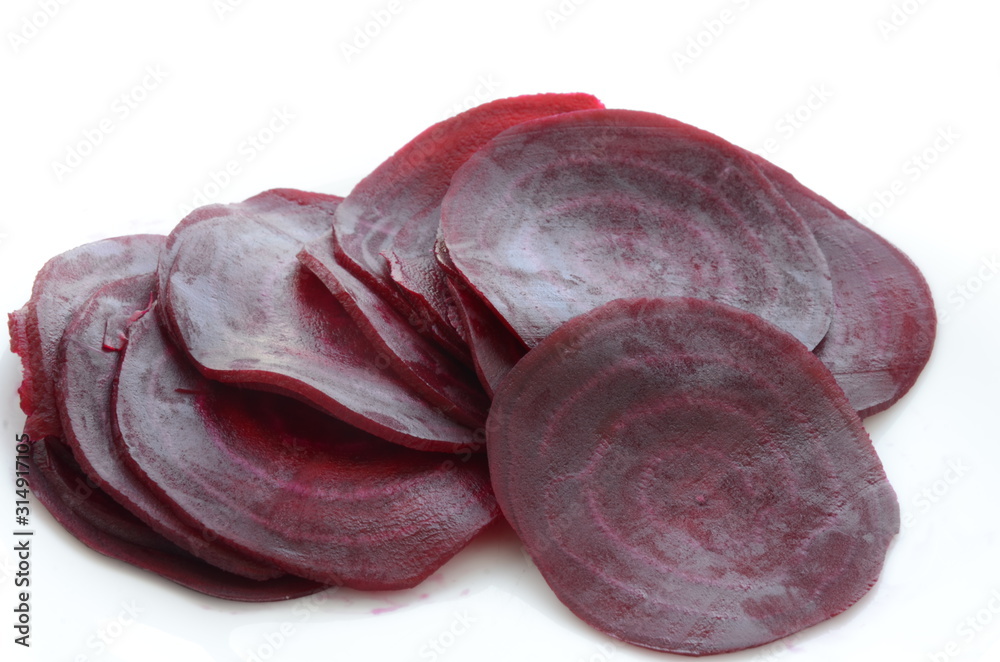 Obraz premium beautifully sliced beetroot stacked on top of each other, round slices of raw and healthy greenery full of vitamins and minerals, vegan and vegetarian healthy food, white background